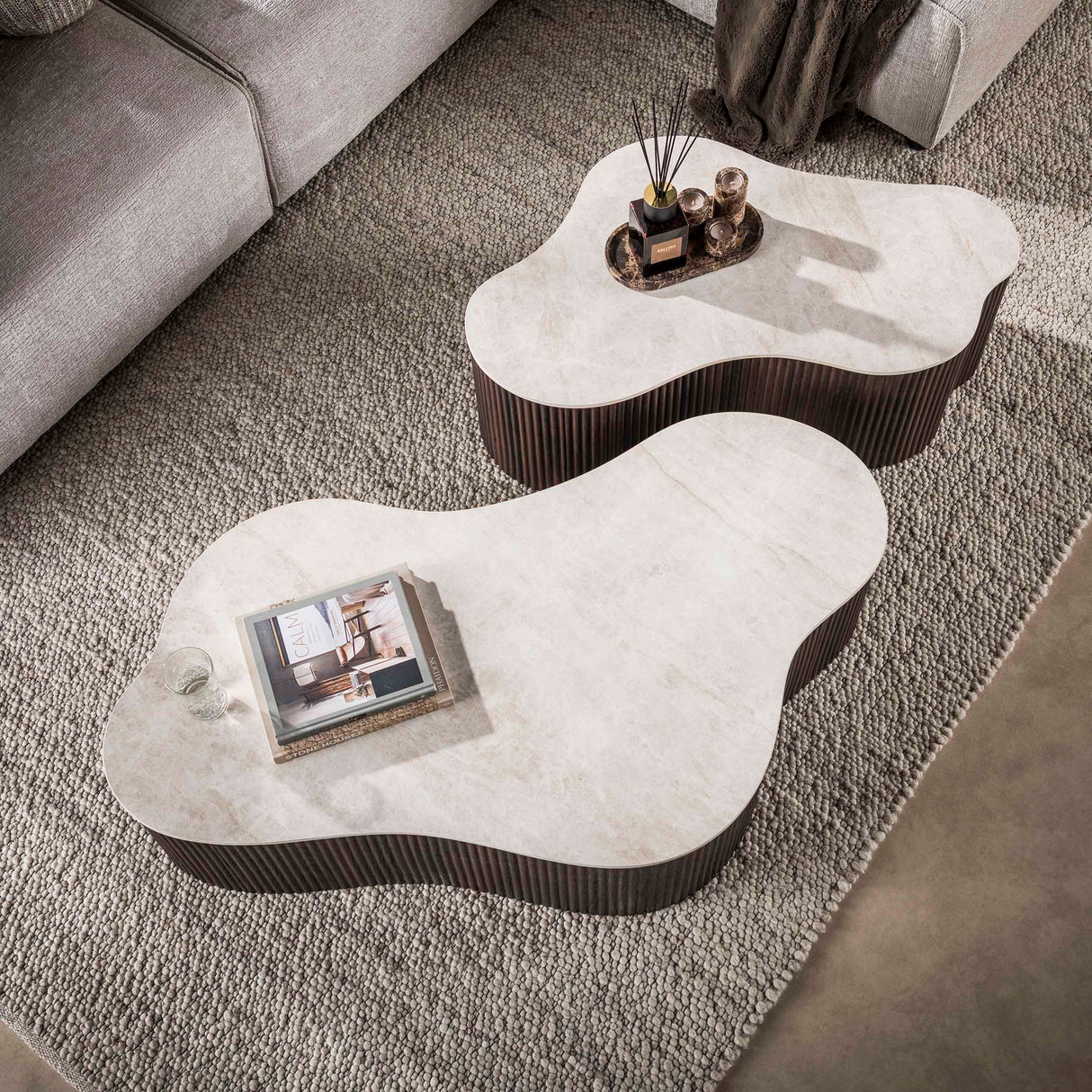 Set of 2 organic Cruz Grand coffee tables with Taj Mahal ceramic tops and dark brown ribbed base.